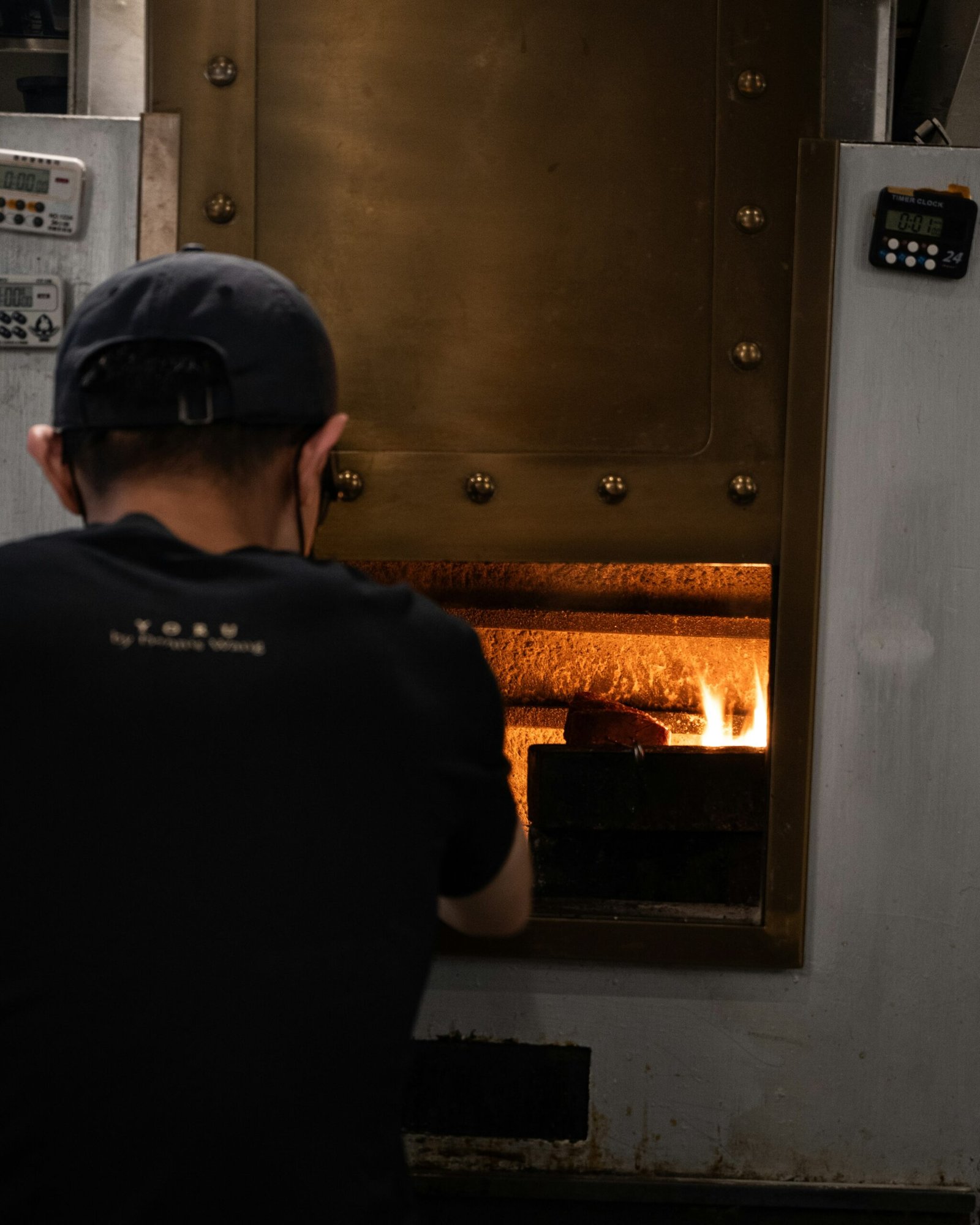 a man standing in front of a metal oven